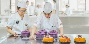 Students at the academy of pastry arts assembling cakes