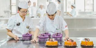 Students at the academy of pastry arts assembling cakes